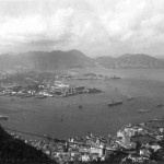 A general view from The Peak looking across Victoria toward Kowloon and the New Territories This was taken in August 1950 and two of the vessels lying at anchor in mid stream are HMS Unicorn (an aircraft carrier) and HMS Ceylon (a cruiser) that were to carry the first contingent of British troops from Hong Kong to Korea to form the 28th Brigade.