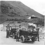 Having finished a day’s survey we head back to the barracks of the 58th in Kowloon. To the left is Jock Robertson, the driver of the jeep, John Flann and to the right Sergeant Mason. This illustrates the small numbers involved in a survey party. The survey gear is in the jeep trailer. Ian Styles was probably the photographer.