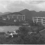 Above is what you see looking north on a typical overcast day from Stanley Barracks. On the far horizon is The Peak, Stanley Mound is behind the first barrack block, then Jardines Lookout and Mount Butler; Below it is Stanley Bay. The building to the left is the NAAFI, then the cookhouse and ablutions. Able Troop was on the first floor of the first barrack block from left, X and C in the next. The Sergeants Mess is to the right along with the Garrison Church. To the left were more barrack blocks occupied by 173 Locating Battery, the MI room, married quarters and officers accommodation all of which was built in the same style. Below is the vehicle park and the Square. Here guards were mounted and we performed riot drill. This shows how vast the Barracks were, which experienced as the miles of roads that we swept.